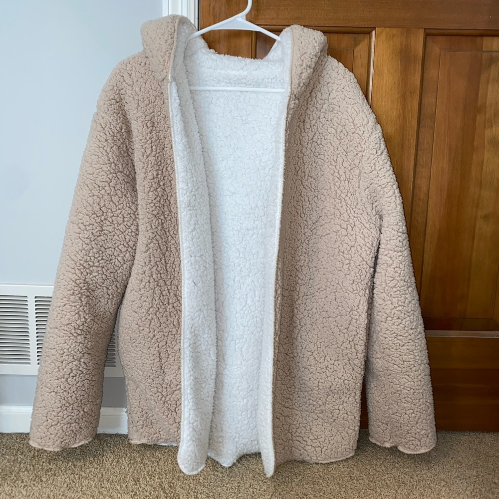 Reversible fuzzy jacket with hood.